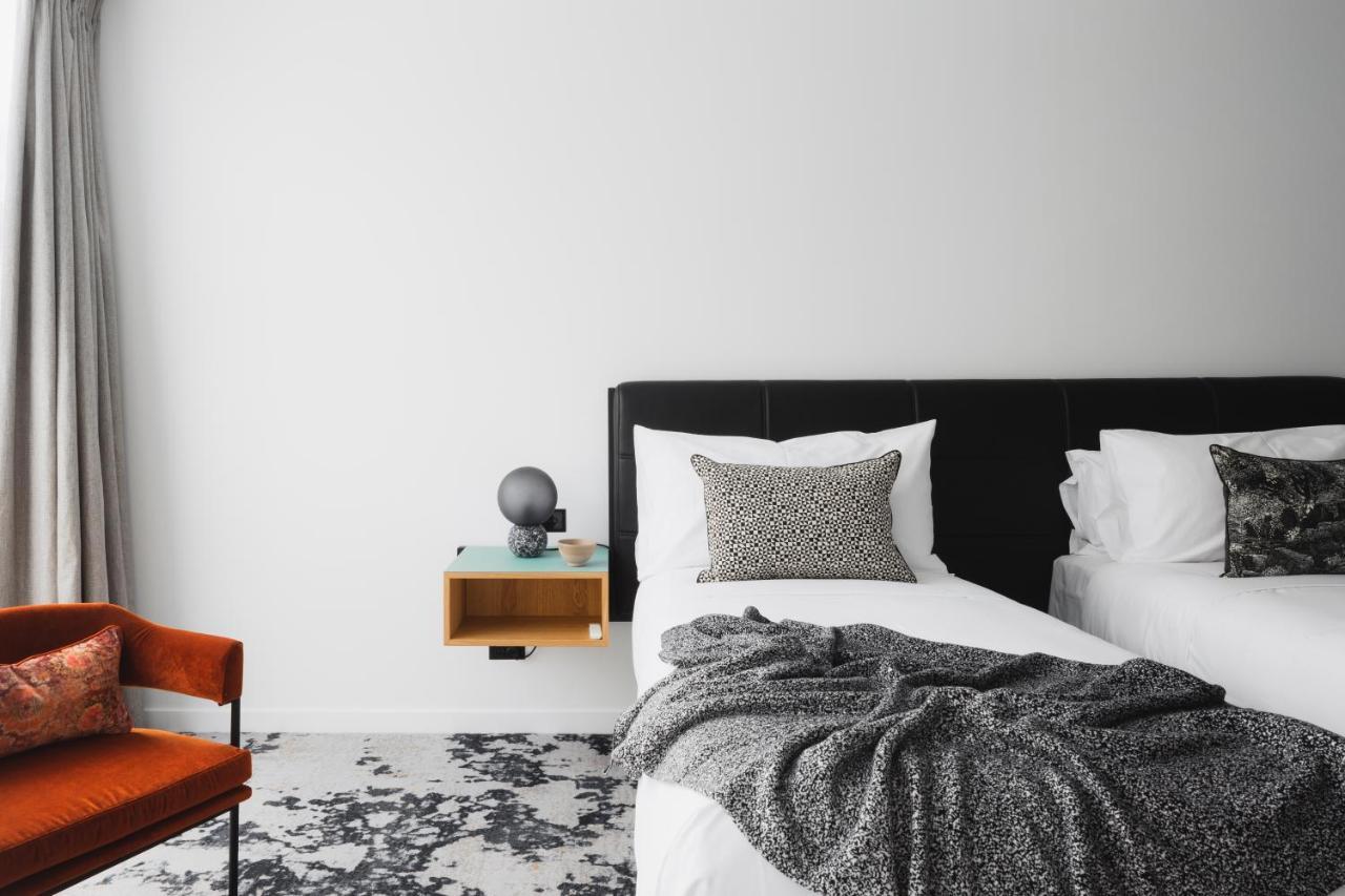 Ebb-Dunedin Exteriör bild A bedroom with a bed, a chair and a nightstand
