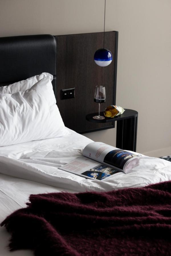 Ebb-Dunedin Exteriör bild A bed with a magazine and a wine bottle